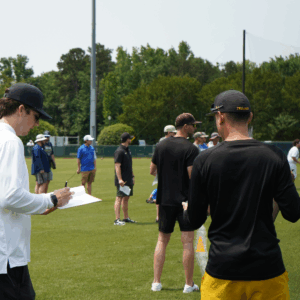 College baseball coaches evaluating players at a committed baseball showcase event in North Carolina